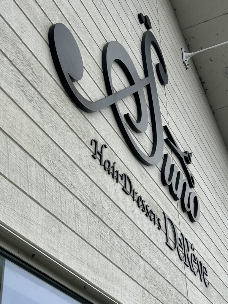 美容室の外壁へチャンネル文字と壁面看板を施工する様子